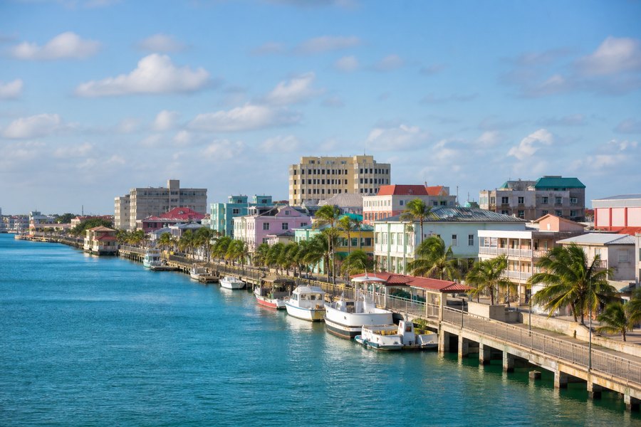 Illustration photographique : le front de mer caribéen, les palmiers et les bateaux de Belize City. Illustration éditoriale, scène imaginaire.