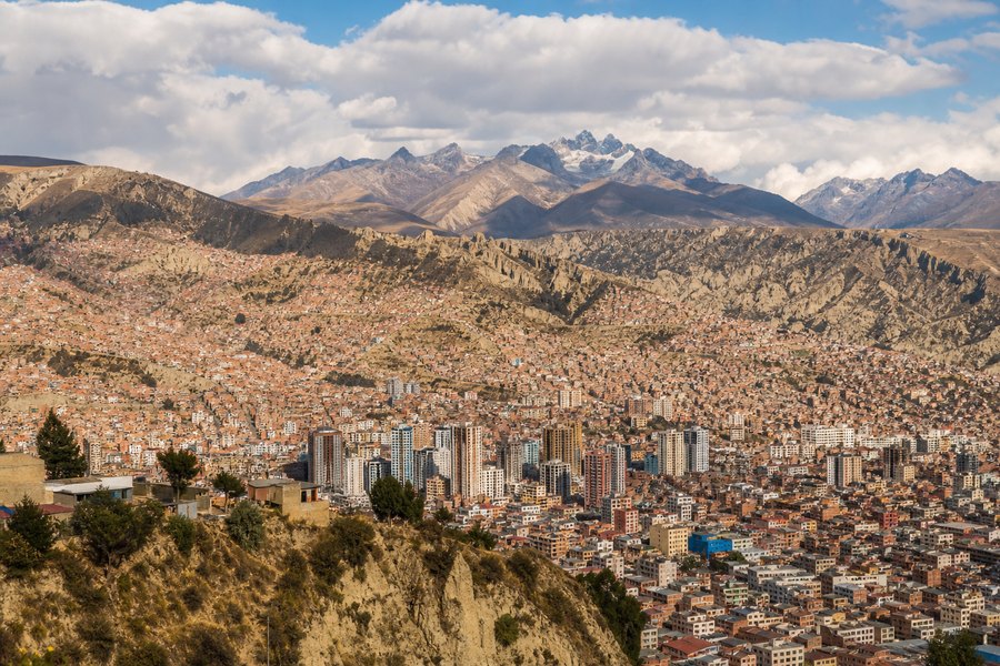 Illustration photographique : la vallée d’altitude, les quartiers en terrasses et les Andes de La Paz. Illustration éditoriale, scène imaginaire.