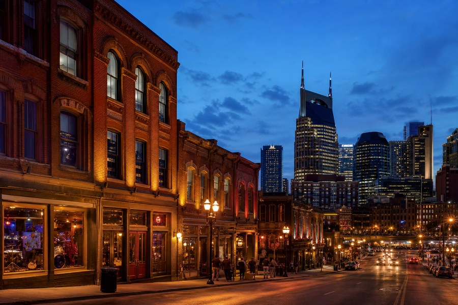Illustration photographique : les façades de briques et la ligne d’horizon de Nashville à la tombée du jour.